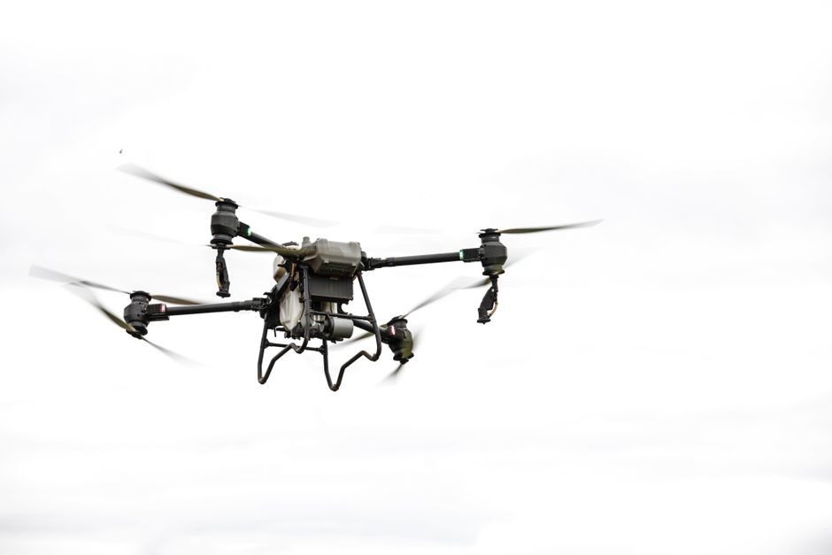A commercial drone inspecting a power line in a utility setting, showcasing advanced technology and safety measures.